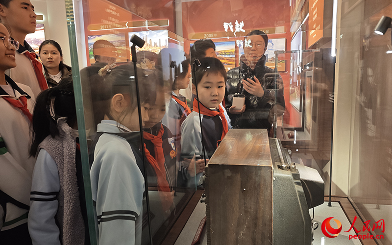 学生们透过天津生产的全国第一台电视机了解天津发展。人民网记者 孙一凡摄
