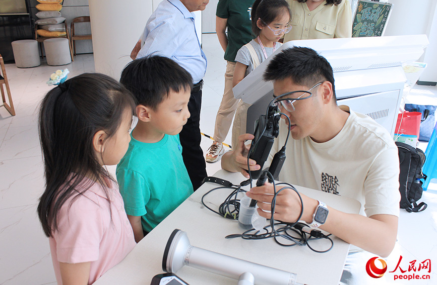 工作人员给孩子们展示环境监测设备。人民网记者 张静淇摄